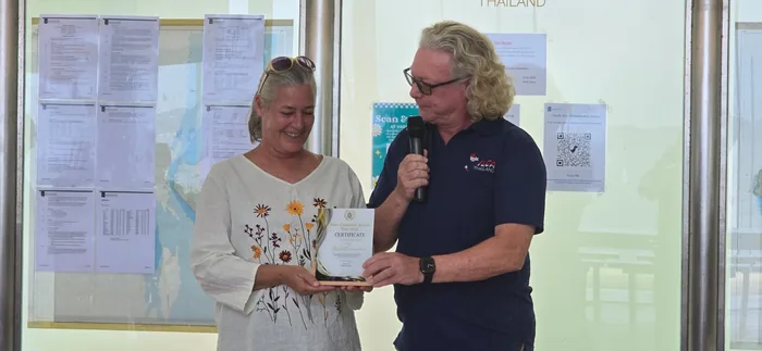 Nima Chandler receiving the commemorative plaque