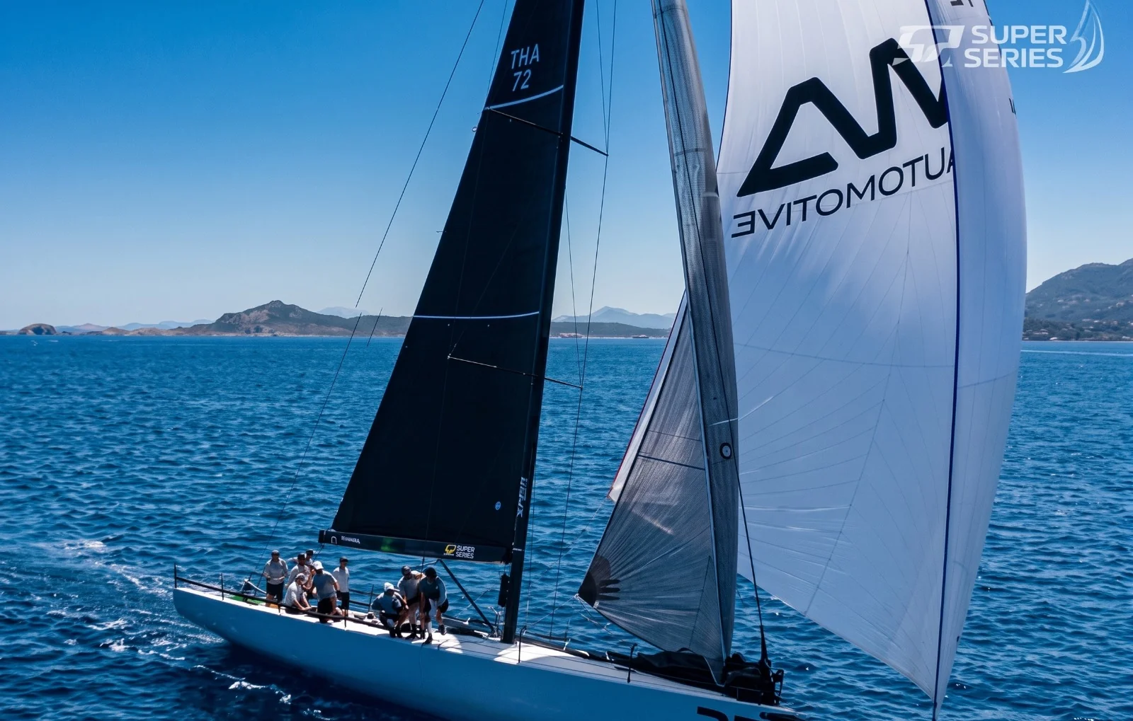 Aerial view of Vāyu, THA 72, sailing under spinnaker on a deep blue sea